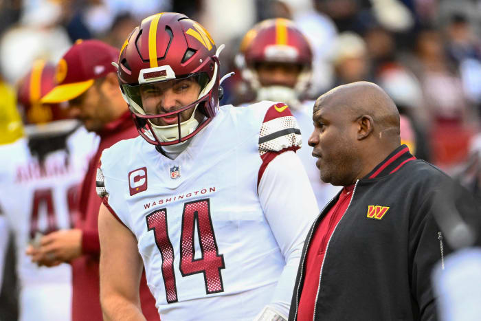Washington Commanders quarterback Sam Howell (14) talks with Washington Commanders offensive coordinator Eric Bieniemy before the game against the Dallas Cowboys at FedExField. Mandatory Credit: Brad Mills-USA TODAY Sports
